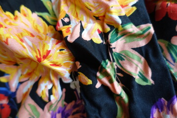 Wrinkled black viscose fabric with colorful floral print