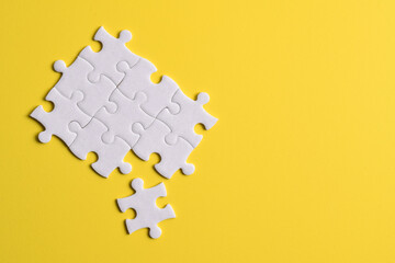 White puzzle pieces on yellow background. Copy space for text, top view.