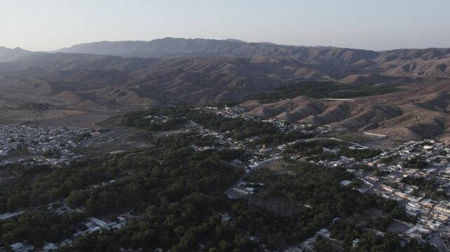 Drone footage at sunrise over Parras de la Fuente, showing urban layout and surrounding terrain under clear sky conditions, captured in stable 4K resolution with smooth tracking and overhead shots.