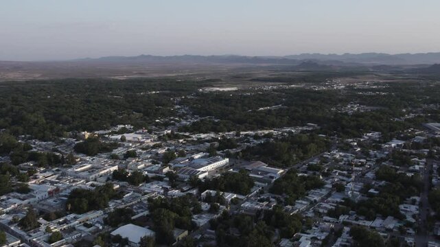Drone footage at sunrise over Parras de la Fuente, showing urban layout and surrounding terrain under clear sky conditions, captured in stable 4K resolution with smooth tracking and overhead shots.