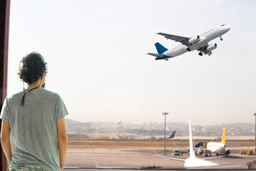 Aviation idea concept. Tourist or passenger waiting for his flight. Man watching planes taking off...