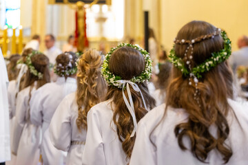 Wianki na głowach dzieci podczas uroczystości Komunii świętej