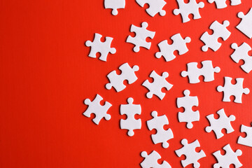 White puzzle pieces on red background, top view. Space for text