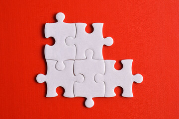 Five puzzle pieces on red background. The concept of finding the right solutions in teamwork.
