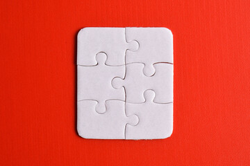 White puzzle pieces on red background, top view. Space for text