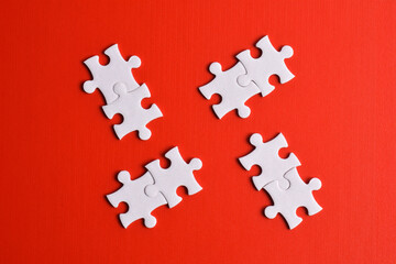 White puzzle pieces on red background, top view