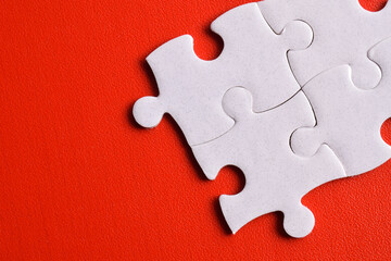 Obraz premium White puzzle pieces on red background, top view