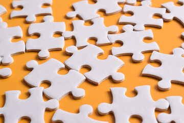 Puzzle background. Puzzle pieces on orange background