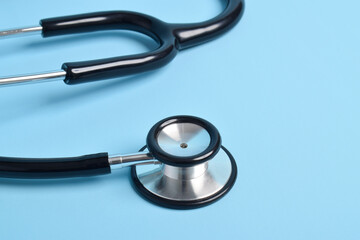 Stethoscope on light blue background, closeup