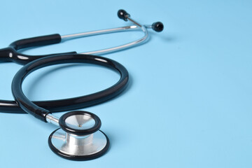 Stethoscope on light blue background, closeup. Space for text