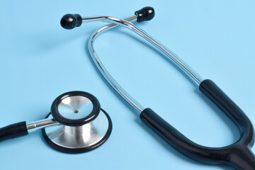 Stethoscope on light blue background, closeup