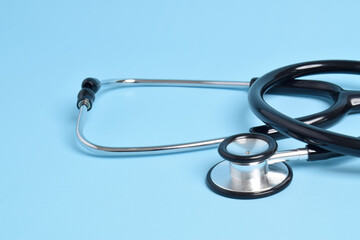 Stethoscope on light blue background, closeup