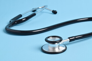 Stethoscope on light blue background, closeup