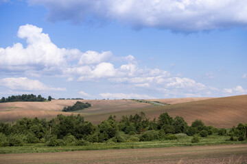 A magical landscape. Rural landscape with a hill and clouds. White fluffy clouds in the sky.