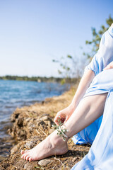 Water nymph. Lake and sunset. Woman in a blue dress. Mavka. Feet by the water. Delicate female hands. Water nymph. Mavka
