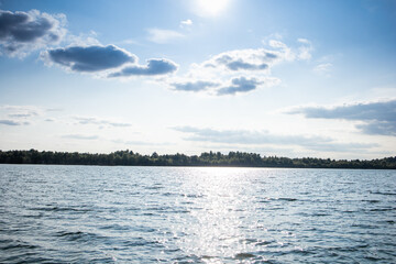 Blue sky and clouds. Lake and blue water. Gentle waves. View