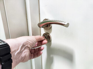 Unlocking a door with a modern handle in a well-lit indoor space during the day