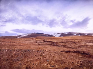 Selbstklebende Fototapeten Expansive mountain landscape under a cloudy sky in a remote location during early morning light © keleny