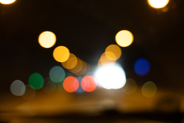 Colorful blurry light circles on a dark background, symbolizing tunnel exit with car lights....
