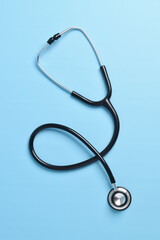 Stethoscope isolated on light blue background, top view. Medical instrument