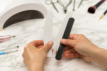 Gel nail manicure at home, female hands with nail files