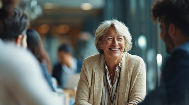 Inclusive professional setting with senior woman executive and multicultural team talking casually during seminar intermission.