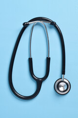 Stethoscope isolated on light blue background, top view. Medical instrument