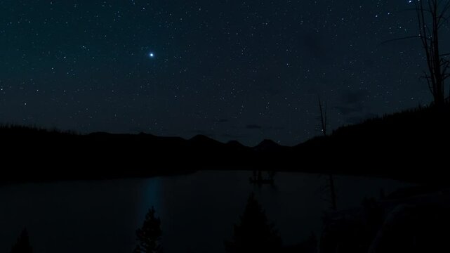 Mountain lake at night under stars bright planet 