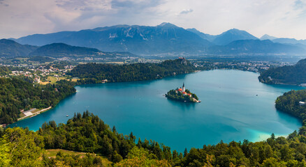 view of turquoise Lake Bled with an island and surrounding mountains from Mala Osojnica hill