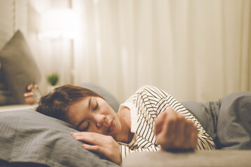 A tired woman wakes early with a headache, struggling with insomnia and fatigue. Low light, stress,...