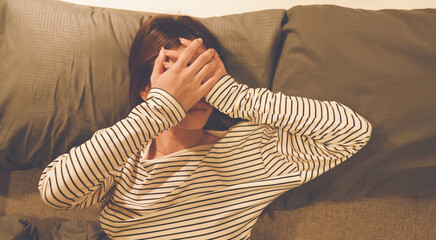 A tired woman wakes early with a headache, struggling with insomnia and fatigue. Low light, stress,...