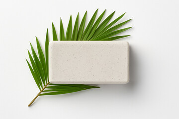 Top View of Rectangular Natural Soap Bar with Palm Leaf on White Background