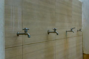 Rows of metallic water taps for ablution