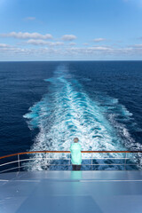 Senior woman from behind at railing of a cruise ship on holiday