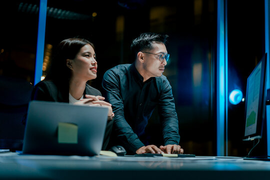 Coworkers work late into the night discussing marketing plans, discussions, suggestions or opinions with business men and women. Working as a team in the evening.
