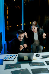 Obraz premium Excited and happy team of colleagues approving projects at night in the office.