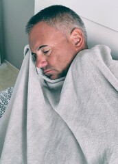 Man in bed with blanket. Sick adult in bed wrapped in blanket. Flu man depressed in bed, rolled up...