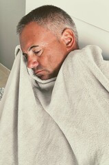 Man in bed with blanket. Sick adult in bed wrapped in blanket. Flu man depressed in bed, rolled up...