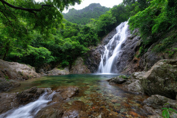 Fototapeta premium Waterfall cascades into a serene pool surrounded by lush greenery in a vibrant rainforest setting