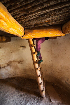 A woman's legs are visible as she climbs a wooden ladder out of the Torreon, a defensive rock tower built in the 1850's by Spanish-American settlers in what is now Lincoln, New Mexico
