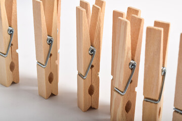 Row of Wooden clothes pins isolated on white background