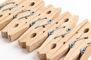 Row of Wooden clothes pins isolated on white background