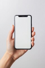 Hand holding modern smartphone with blank screen on light background