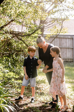 Mother with kids checking a piece of leaf.