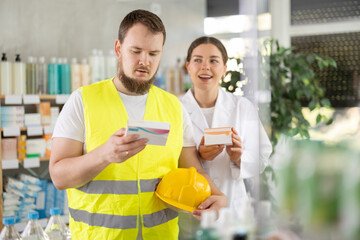 Builder chooses painkillers and paracetamol, and the female pharmacist offers additional...