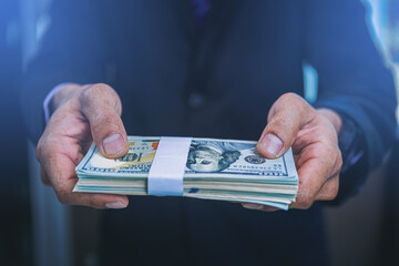 Businessman holding money banknotes and making decision for business investment. Selected focus