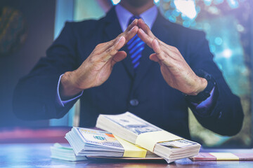 Businessman making hands to protect sign covering cash money. Banking and money sucurity concept