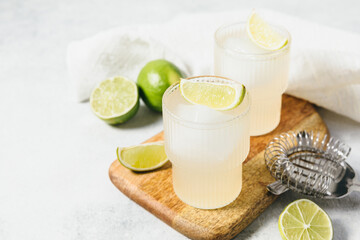 Refreshing detox citrus drink. Vitamin water with lime slices and ice cube on wooden board....