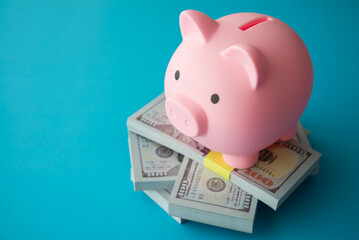Pink piggy bank on stack US dollar bill banknotes. Wealth management, money saving, personal financial planning, return on investment, savings for retirement and so on concept.