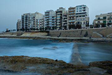 Long exposure shot of sea and apartment buildings in Tas-Sliema, Malta 